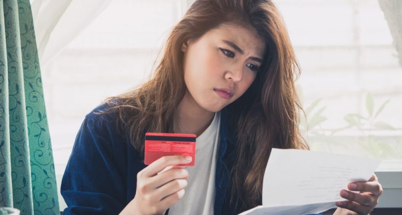 stressed young asian woman trying to find money to pay credit card debt.
