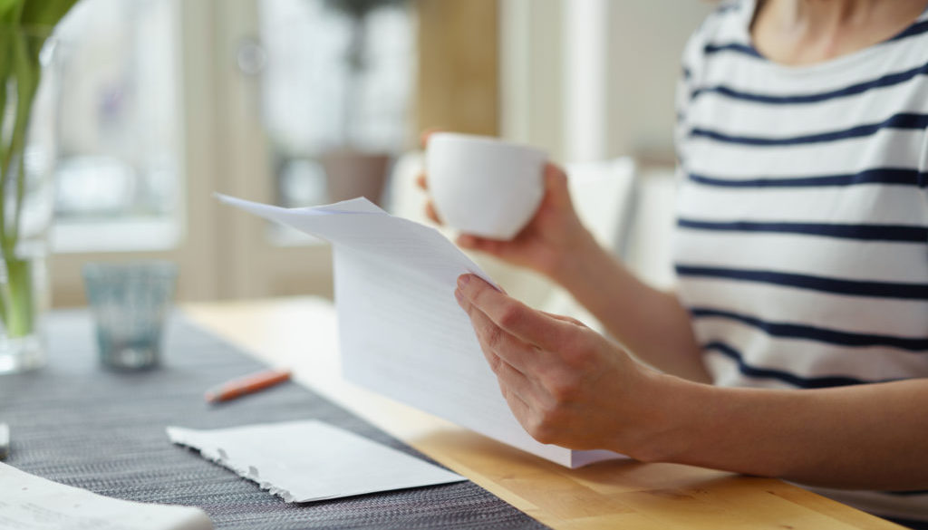 Woman Reading Charge-Off Letter from Creditor