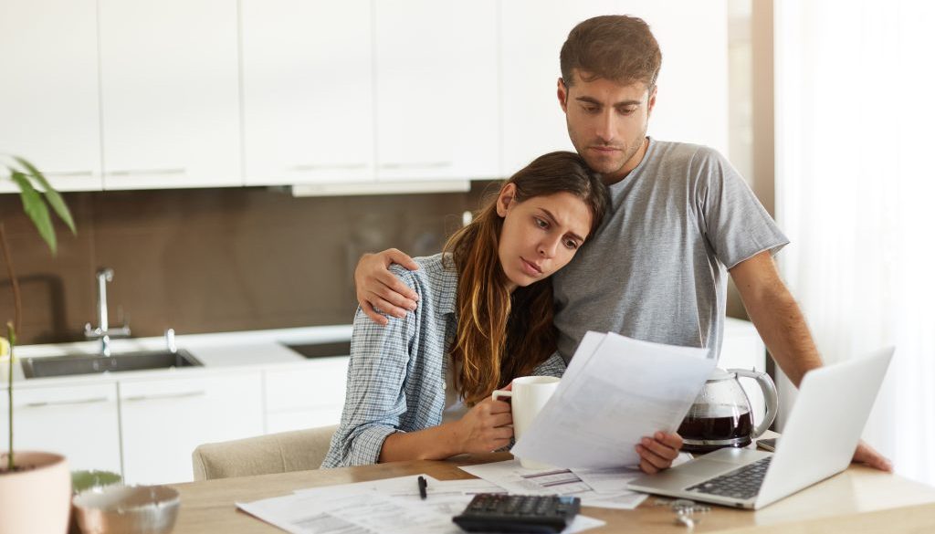 Couple looking worried at paperwork - Facing Bankruptcy