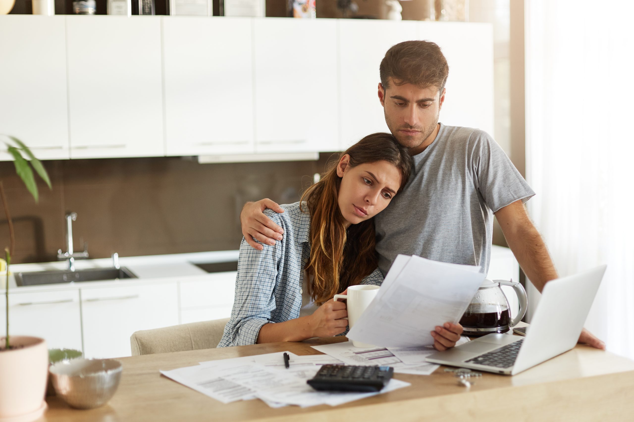 Couple looking worried at paperwork - Facing Bankruptcy
