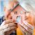 New house concept, happy senior couple holding small home model