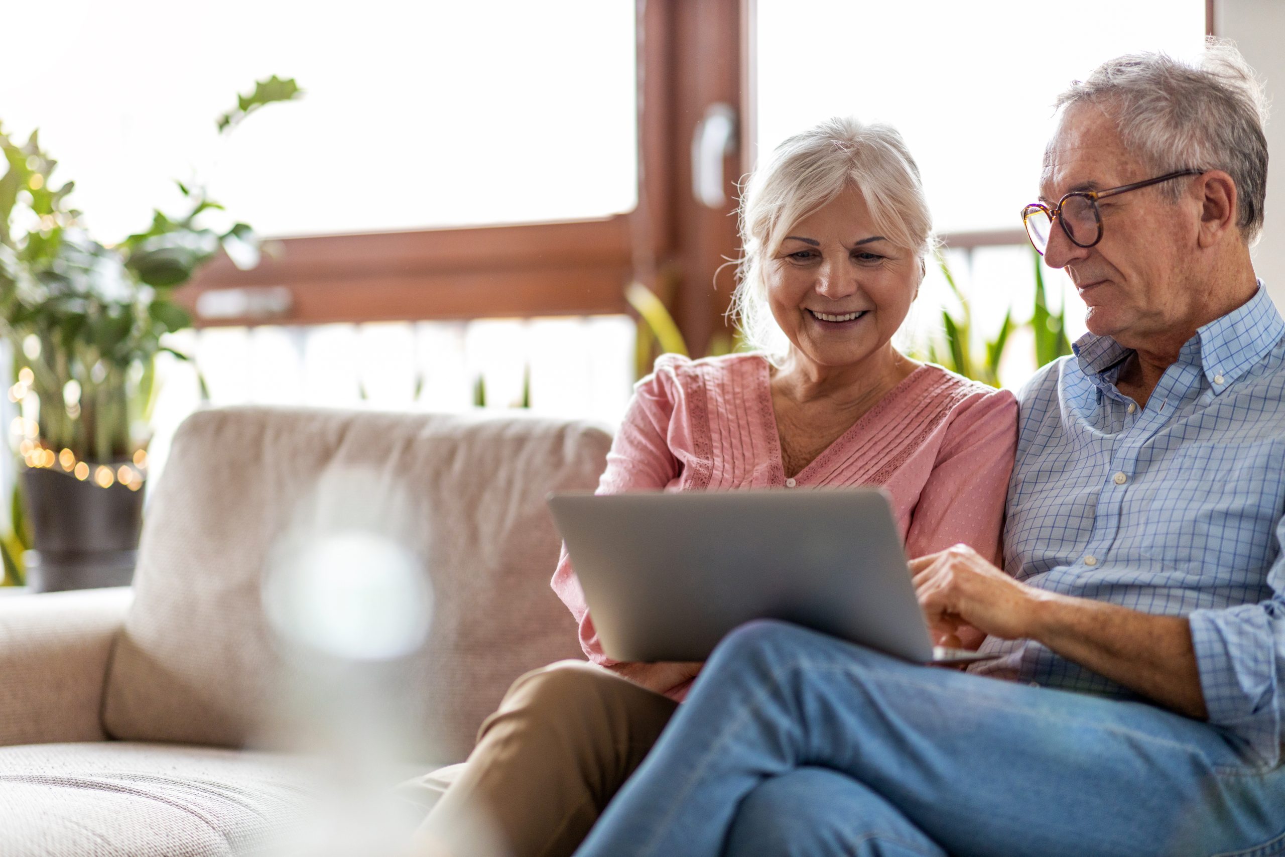 Mature couple using a laptop while relaxing at home