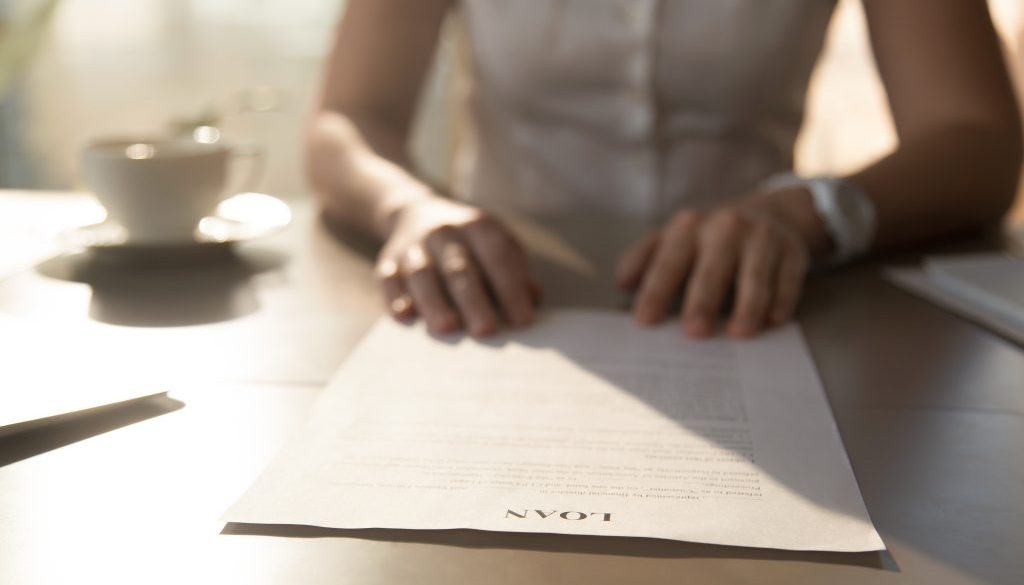 Woman sitting at the desk with loan agreement form