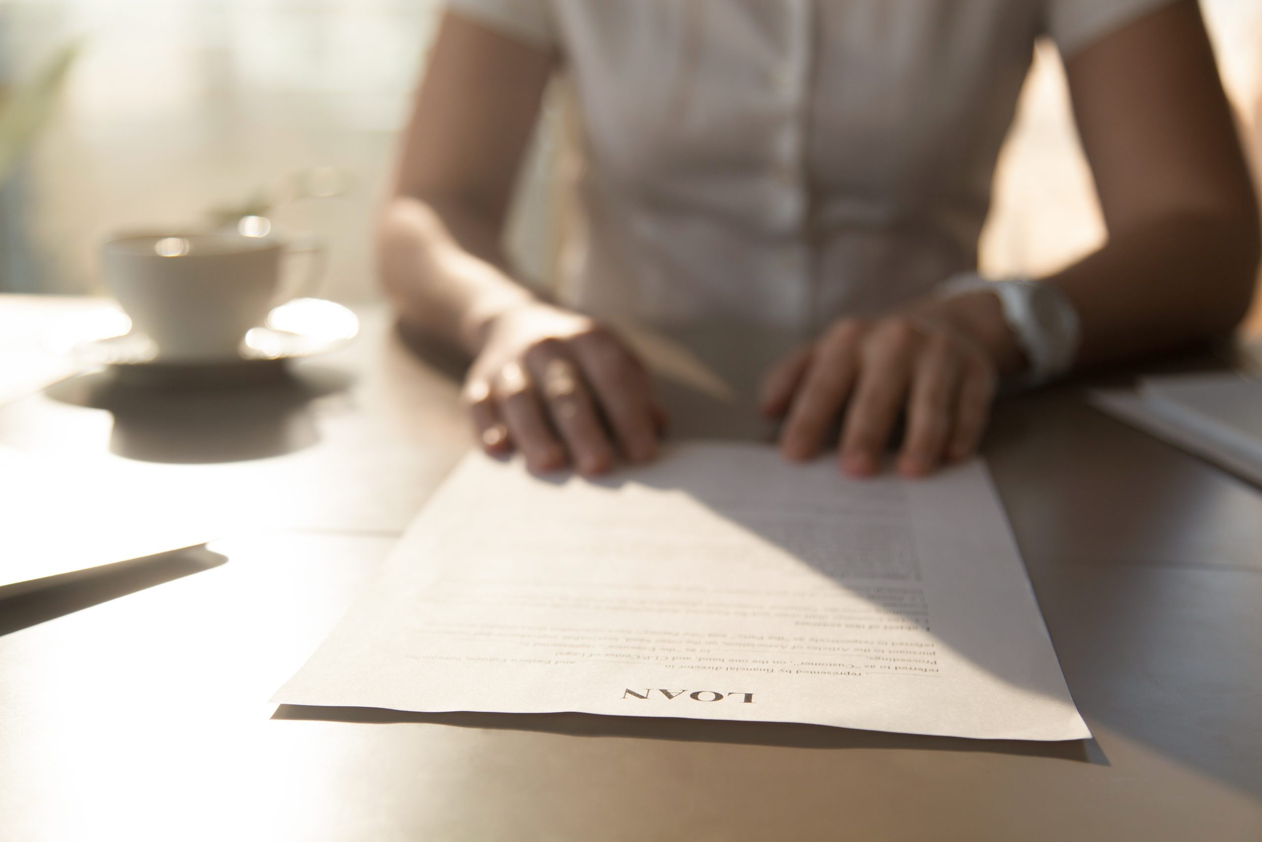 Woman sitting at the desk with loan agreement form