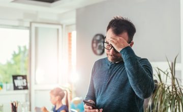 Worried father looking at smart phone