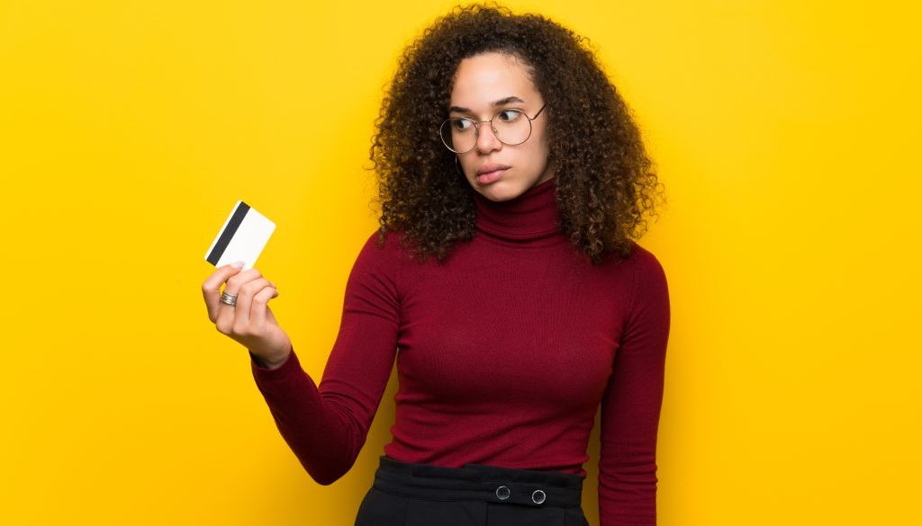 Dominican woman with turtleneck sweater taking a credit card without money