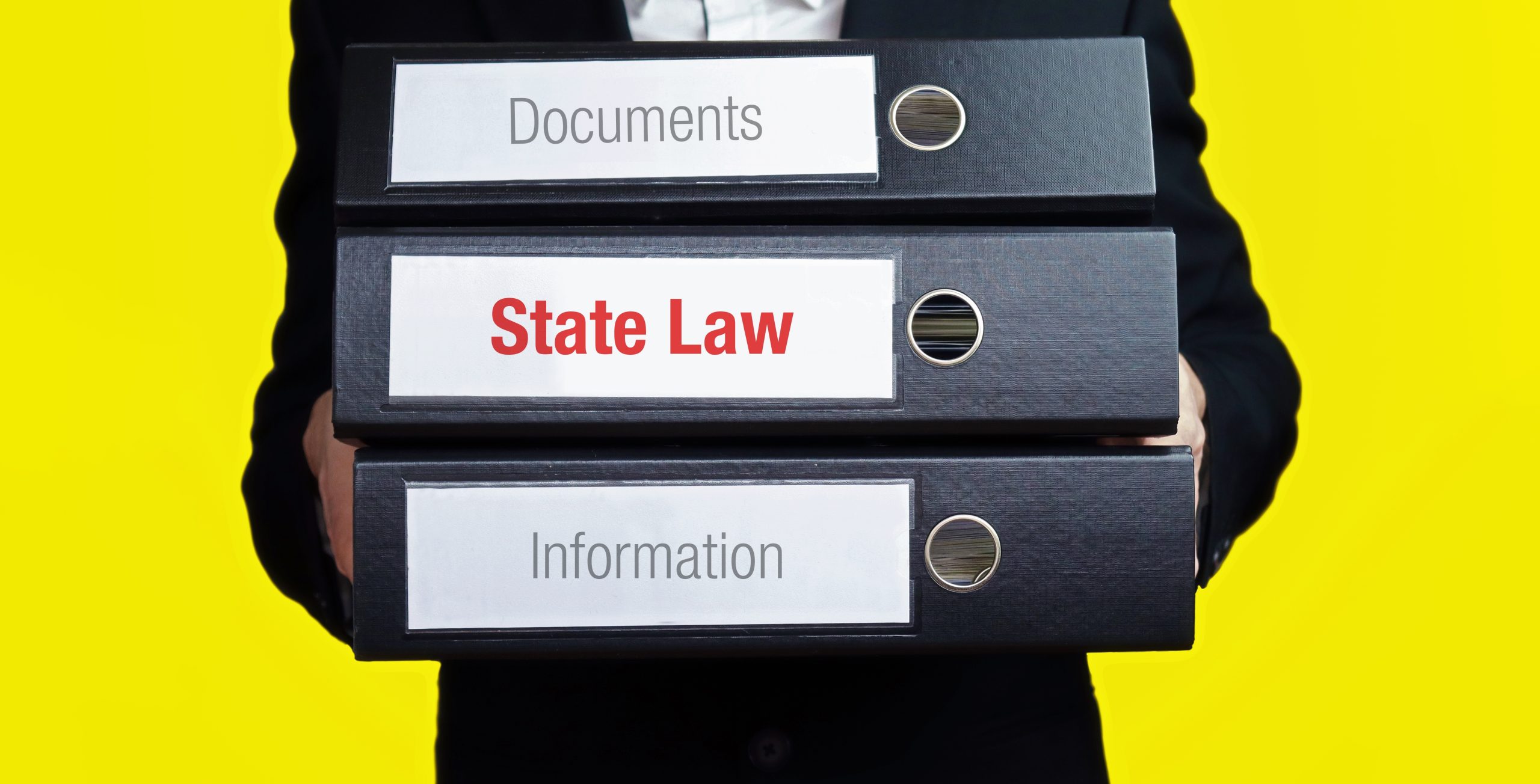State Law – finance/economics. Man carries a stack of 3 file folders. A folder has the label State Law. Business, statistics concept