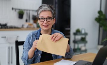 woman holding a postal envelope with mail, financial report.