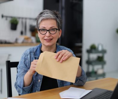 woman holding a postal envelope with mail, financial report.