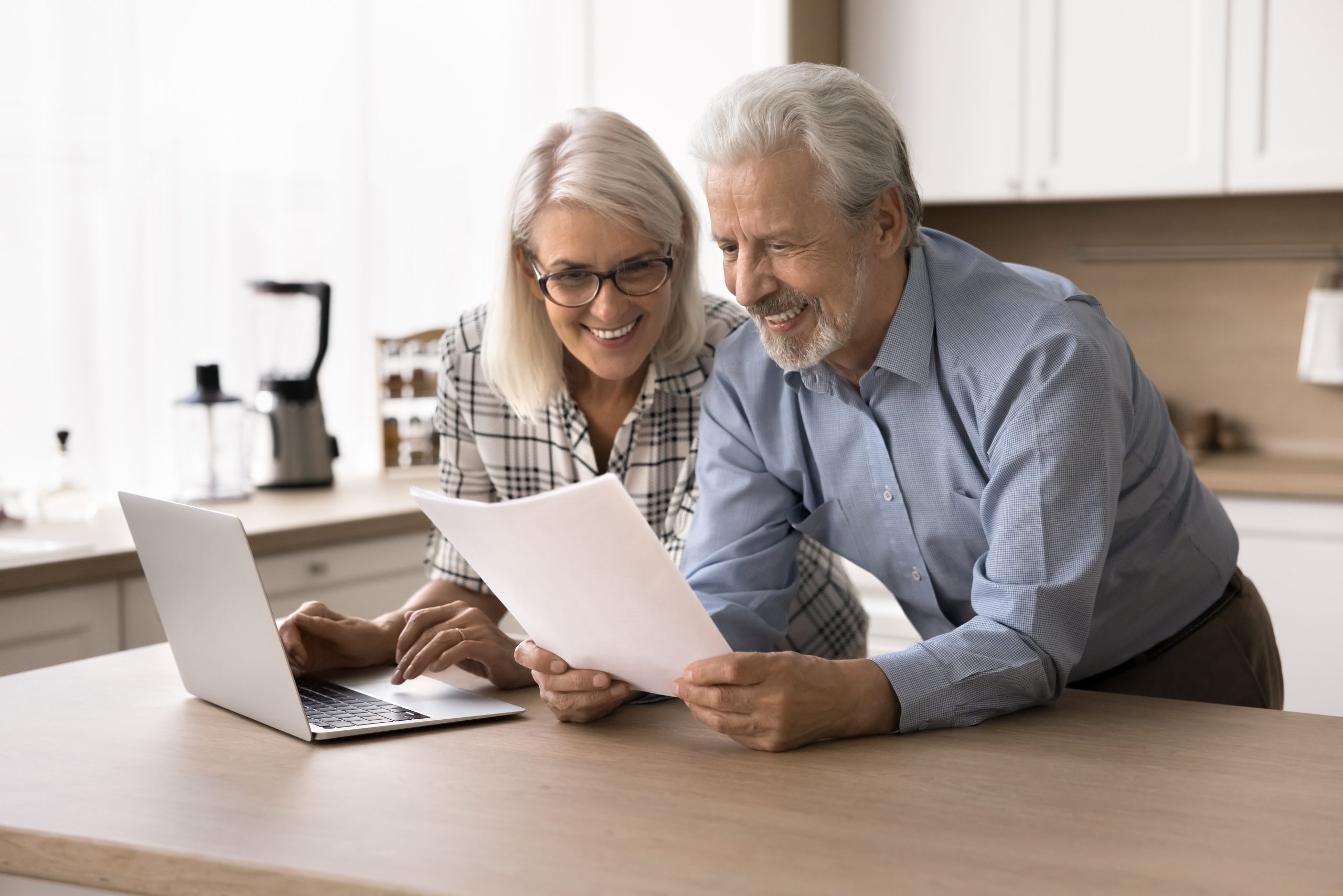 Happy elderly couple read bank notice with positive news