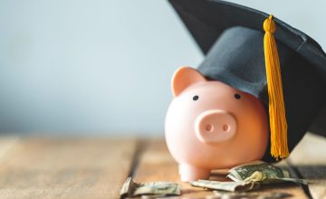 piggy bank With Graduation Cap on old wood,Money saving concept. piggy bank With Graduation Cap on old wood,Money saving concept.