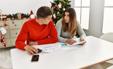 Young couple controlling family economy sitting on the table at home.