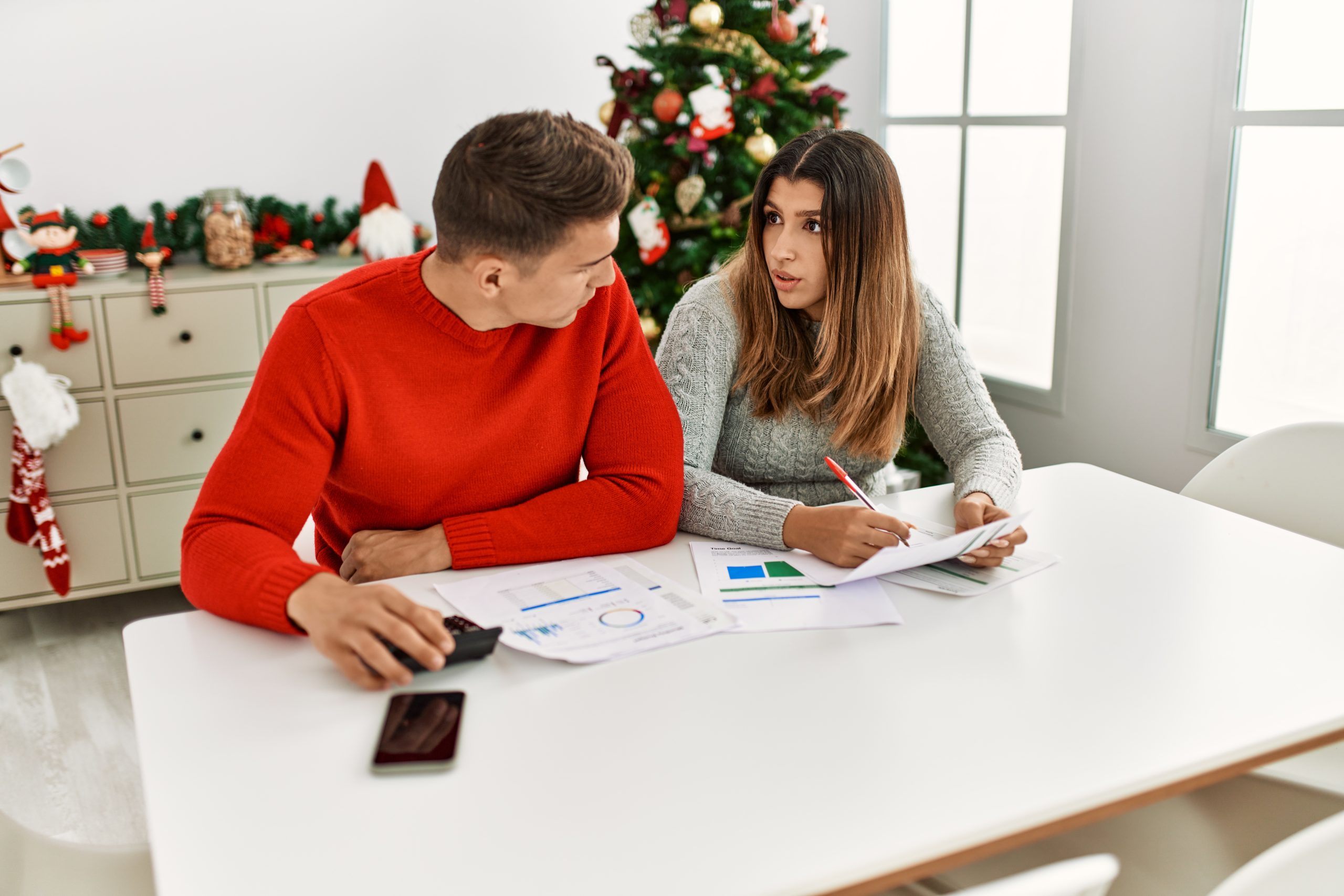 Young couple controlling family economy sitting on the table at home.